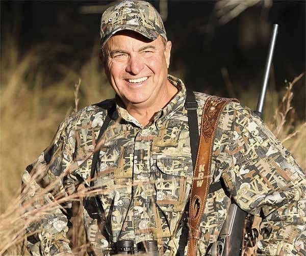 Keith Warren smiles while wearing camo with an airgun hanging off his shoulder