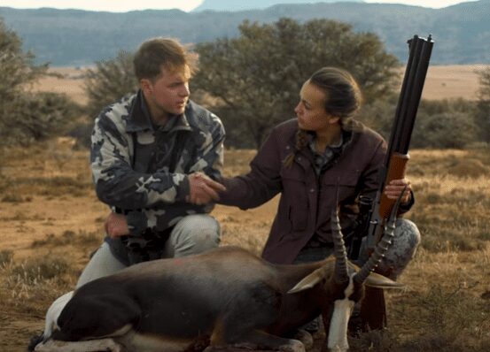Mattie shakes the hand of the Bontebok she just hunted. her cameraman in front of
