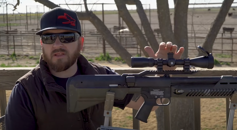 Man wearing a hat and sunglasses displays the Umarex Hammer airgun.